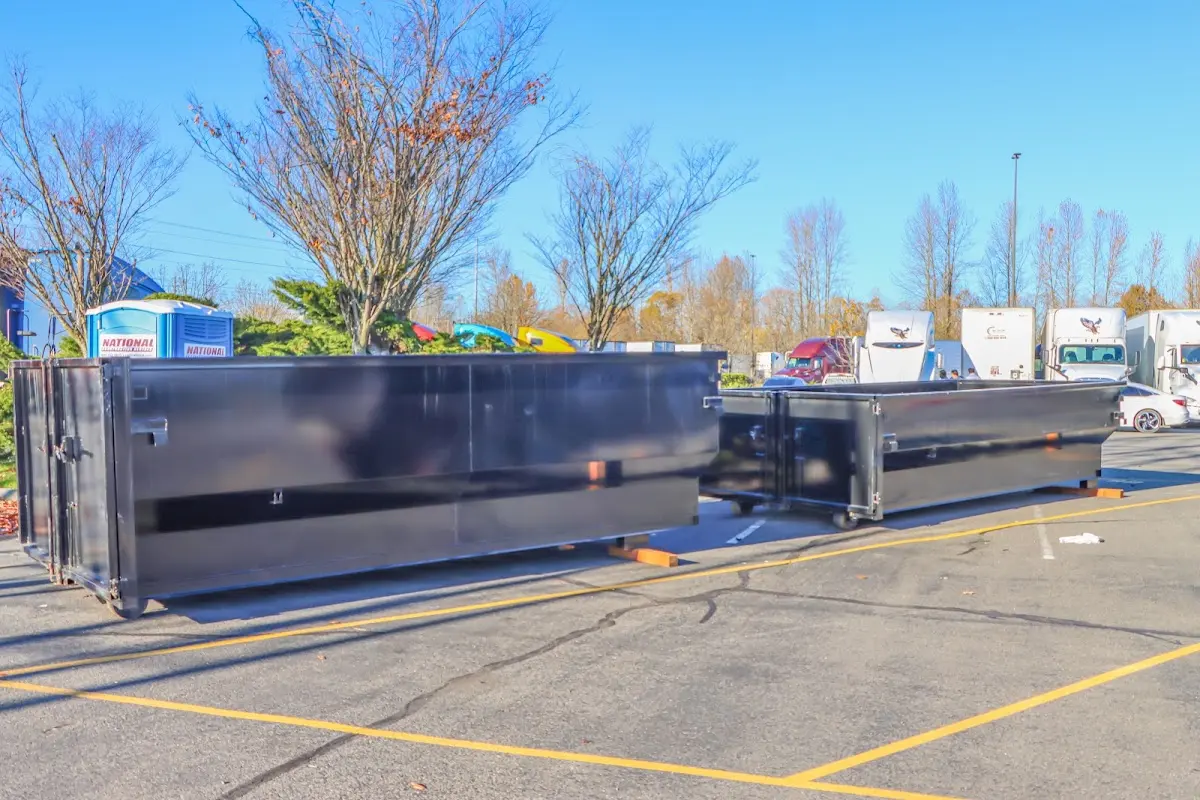 Professional dumpster rental service with roll-off container on residential driveway in River Grove
